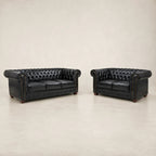Black leather Chesterfield sofa and loveseat set with tufted design and rolled arms