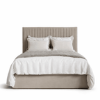 Cream upholstered bed with panelled headboard and plush bedding, modern luxury style