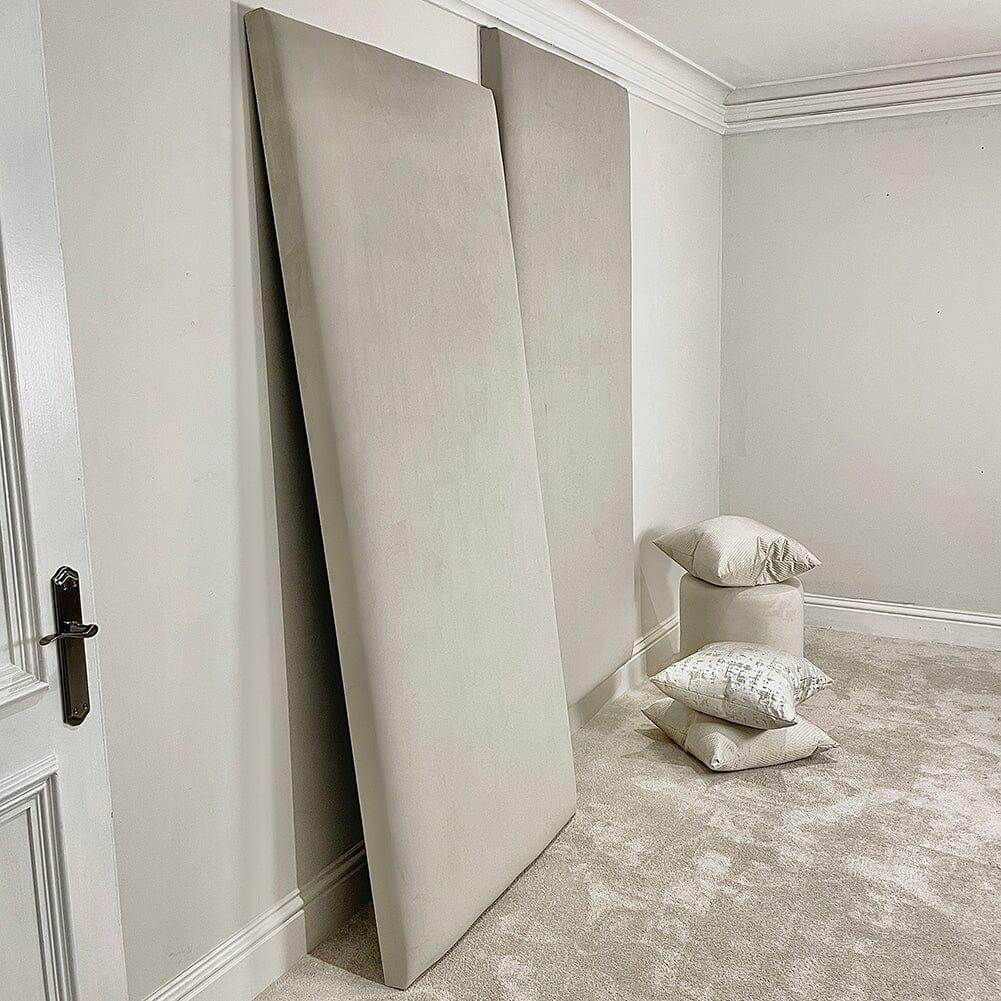 Cream velvet double-width upholstered headboard panels and neutral pillows in a modern bedroom