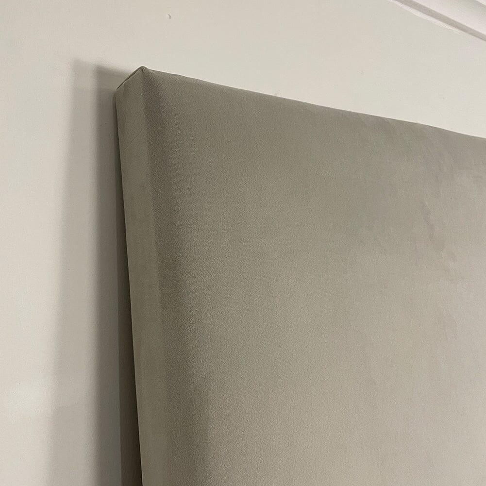 Cream velvet upholstered headboard wall panel with smooth, minimalist design against a light wall.