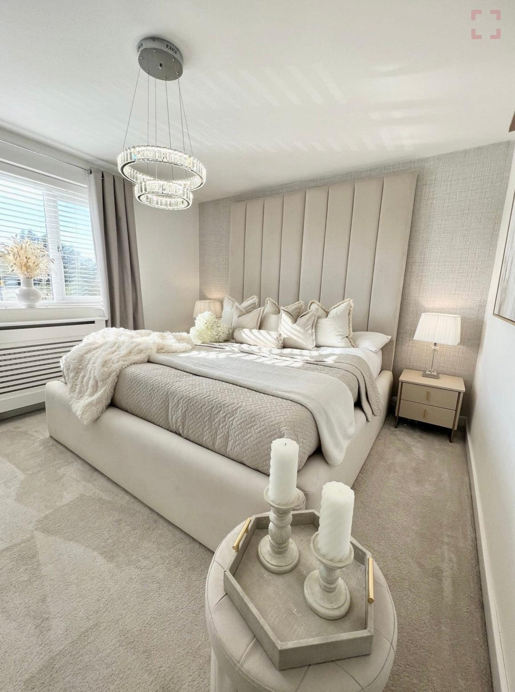 Cream panelled double bed in a modern bedroom with neutral decor and plush bedding