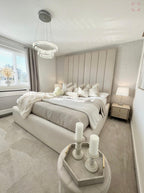 Cream panelled double bed in a modern bedroom with neutral decor and plush bedding