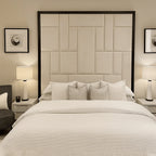 Modern double bed with large wall-mounted upholstered headboard, neutral bedding, lamps