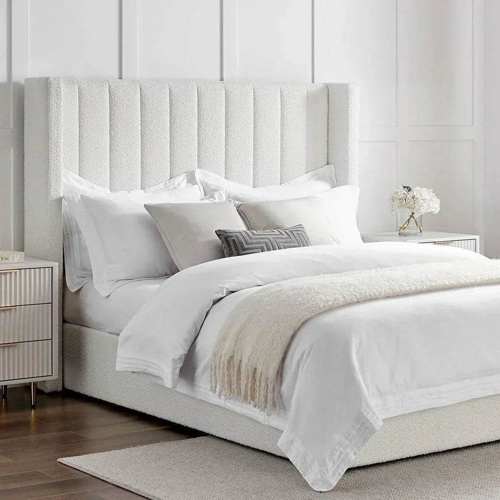 Modern double boucle ottoman storage bed with tall headboard, white bedding, and accent pillows