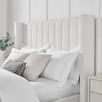 Bouclé fabric ottoman storage bed with tall fluted headboard and neutral bedding in modern bedroom