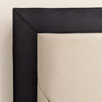 Close-up of modern double bed with sunburst padded headboard in cream and black fabric