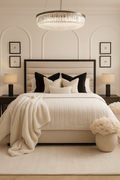 Modern cream panelled bed with black and cream pillows in a luxury styled bedroom