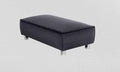 Modern black fabric footstool with metal legs against a light textured background