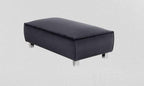 Modern black fabric footstool with metal legs against a light textured background