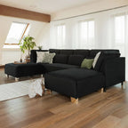 Modern black U-shape corner sofa with scatter cushions in a bright living room
