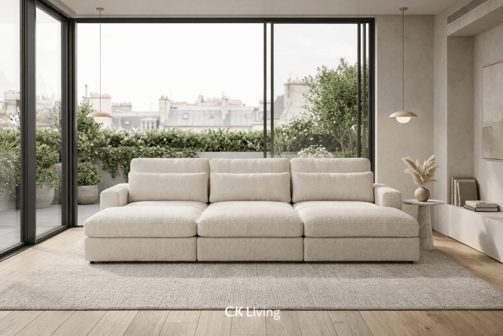 Modern cream cinema sofa in a bright living room with large windows and greenery outside
