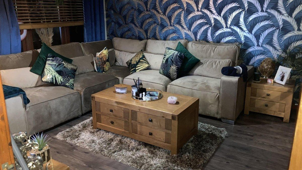Modern grey corner sofa with botanical cushions and wooden coffee table in a cozy living room