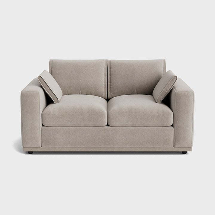 Modern cream two-seater sofa with clean lines and two matching side cushions
