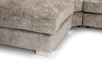 Close-up of a modern beige corner sofa with plush cushions and chrome legs on white floor
