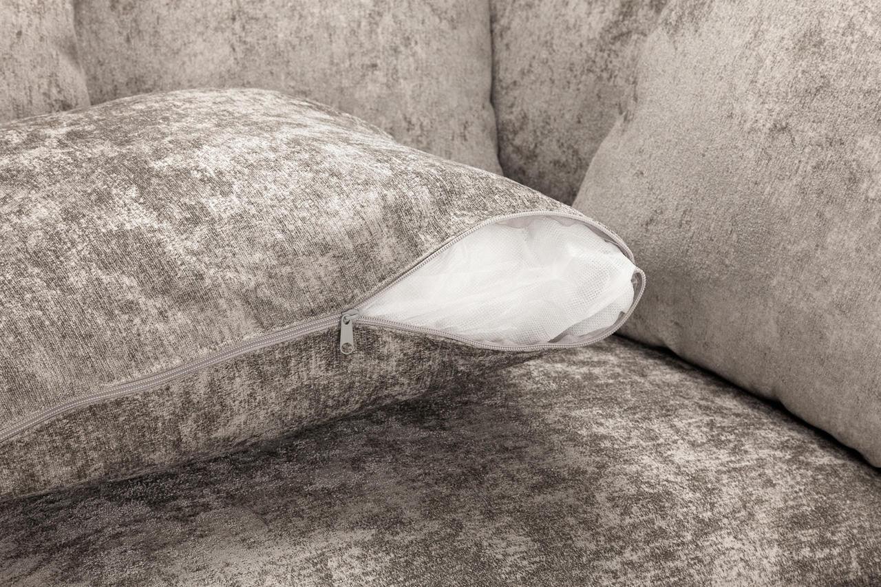 Close-up of a grey textured sofa cushion with a visible zip opening and inner lining