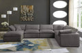 Modern cream footstool and large 6-seater grey modular corner sofa in a stylish living room