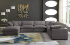 Modern cream footstool and large 6-seater grey modular corner sofa in a stylish living room
