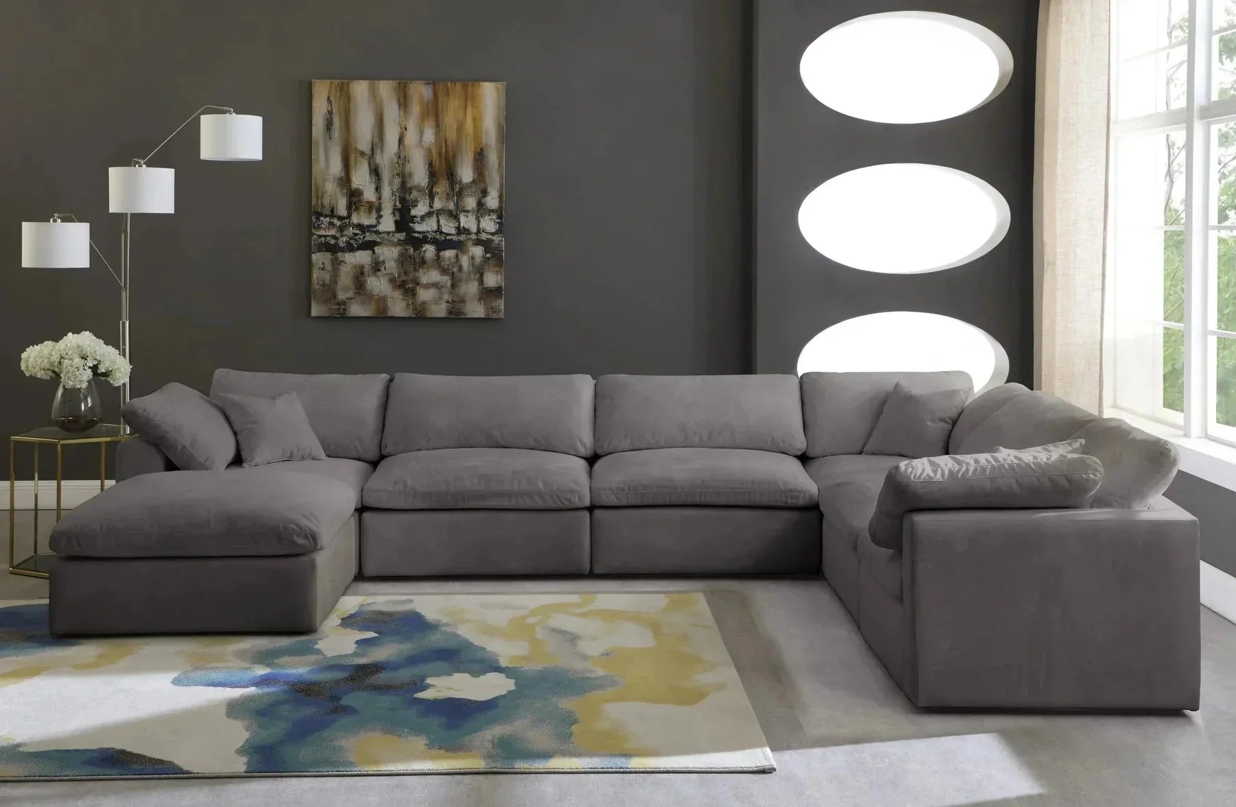Modern cream footstool and large 6-seater grey modular corner sofa in a stylish living room