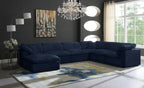 Large navy blue modular corner sofa in modern living room with chandelier and abstract rug