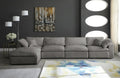 Cream modular corner sofa with chaise in modern living room, abstract rug and dark walls