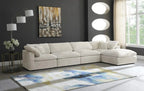 Cream modular corner sofa with plush cushions in a modern living room with grey walls and abstract decor.