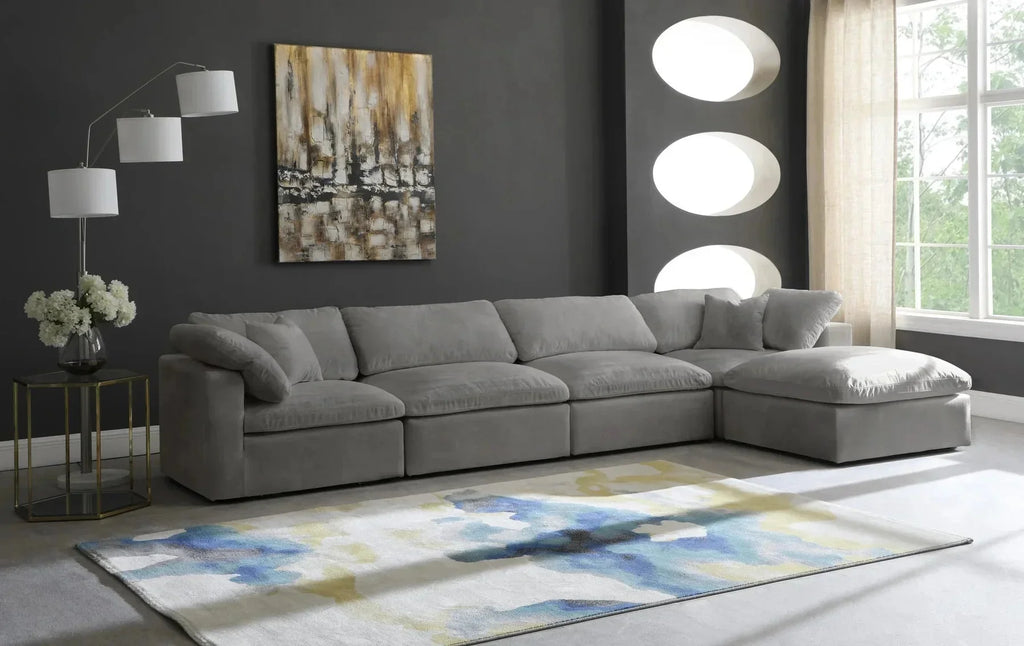 Modern living room with large grey modular corner sofa, abstract rug, and dark accent wall.