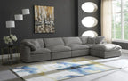 Modern living room with large grey modular corner sofa, abstract rug, and dark accent wall.