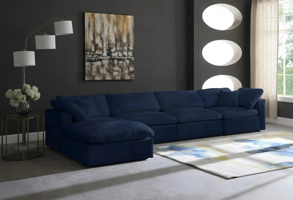 Modern living room with a navy blue modular corner sofa, abstract wall art, and floor lamp