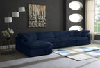 Modern living room with a navy blue modular corner sofa, abstract wall art, and floor lamp