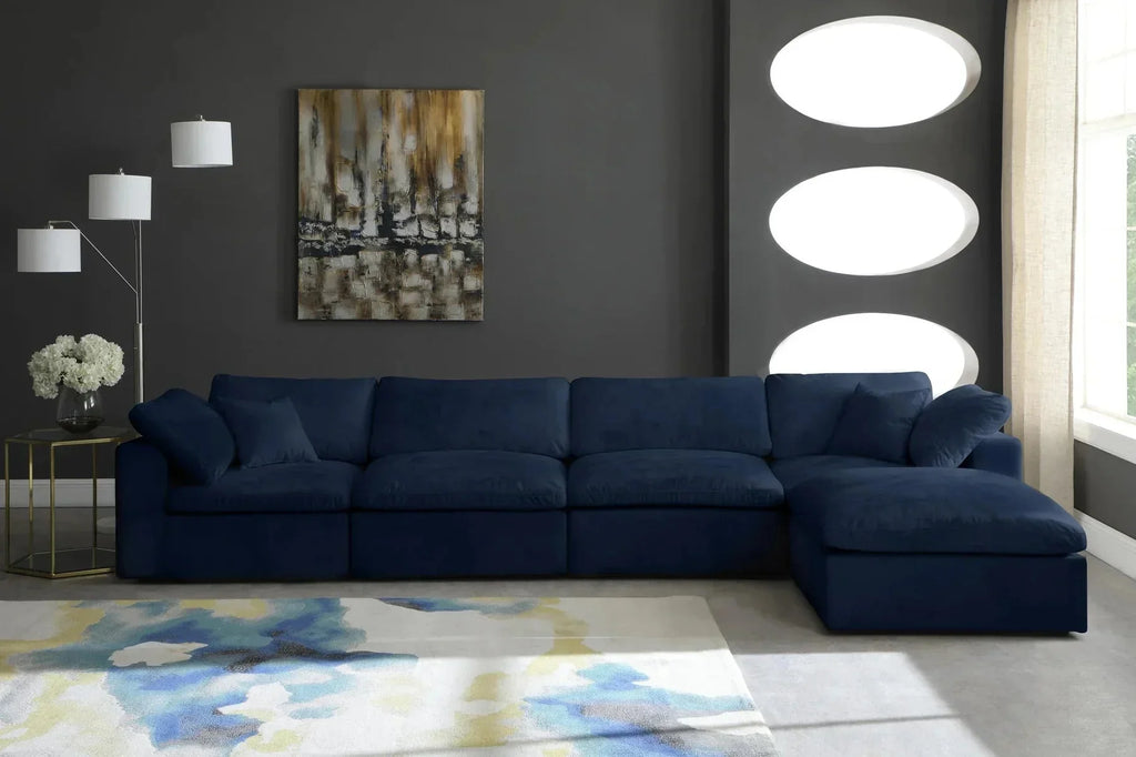 Modern living room with dark blue modular corner sofa, abstract rug, and contemporary decor