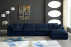 Modern living room with dark blue modular corner sofa, abstract rug, and contemporary decor