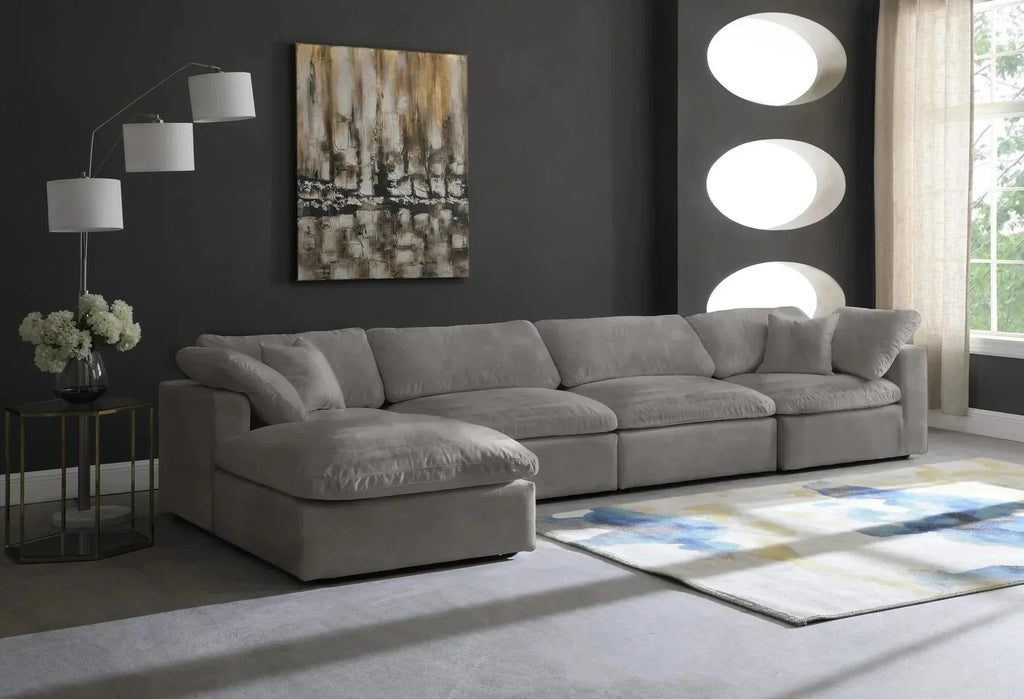 Modern cream modular corner sofa with chaise in a stylish living room with dark walls, abstract art, and a patterned rug