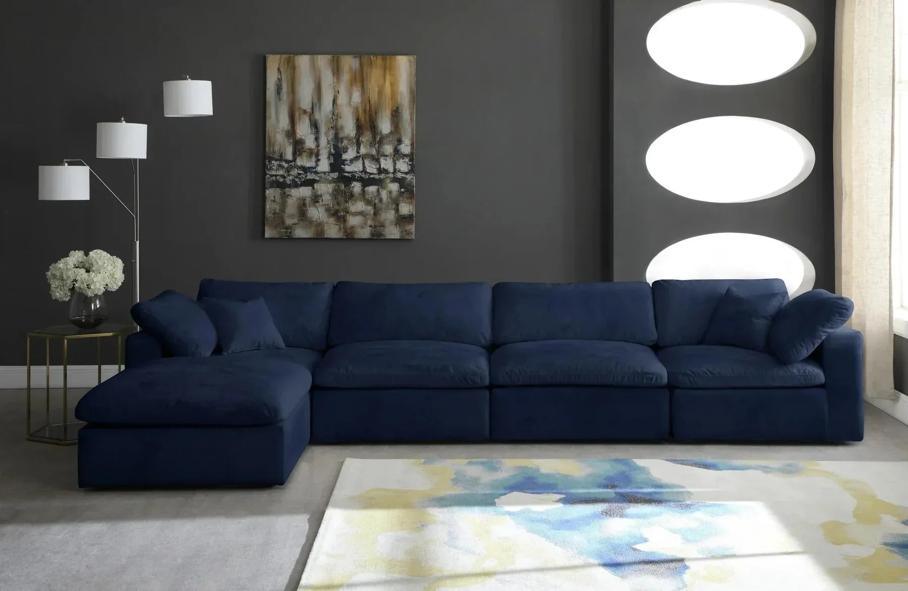 Modern navy blue 4-seater modular corner sofa in stylish living room with abstract rug