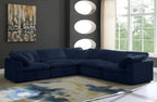 Modern living room with large navy blue 5-seater corner sofa, abstract rug, and wall art