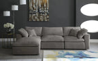 Cream modular corner sofa with footstool in modern living room, abstract rug, and wall art