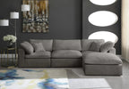 Modern living room with a grey modular corner sofa, abstract rug, and dark accent wall.