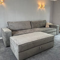 Large grey fabric sofa with matching storage footstool in a modern living room