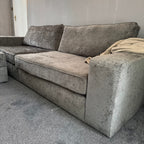 Large grey fabric sofa with storage footstool in a modern living room
