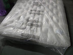 Emperor size luxury mattress in protective plastic wrap, tufted surface, on showroom floor