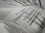 Close-up of Vispring luxury mattress with embroidered label and tufted cotton fabric.