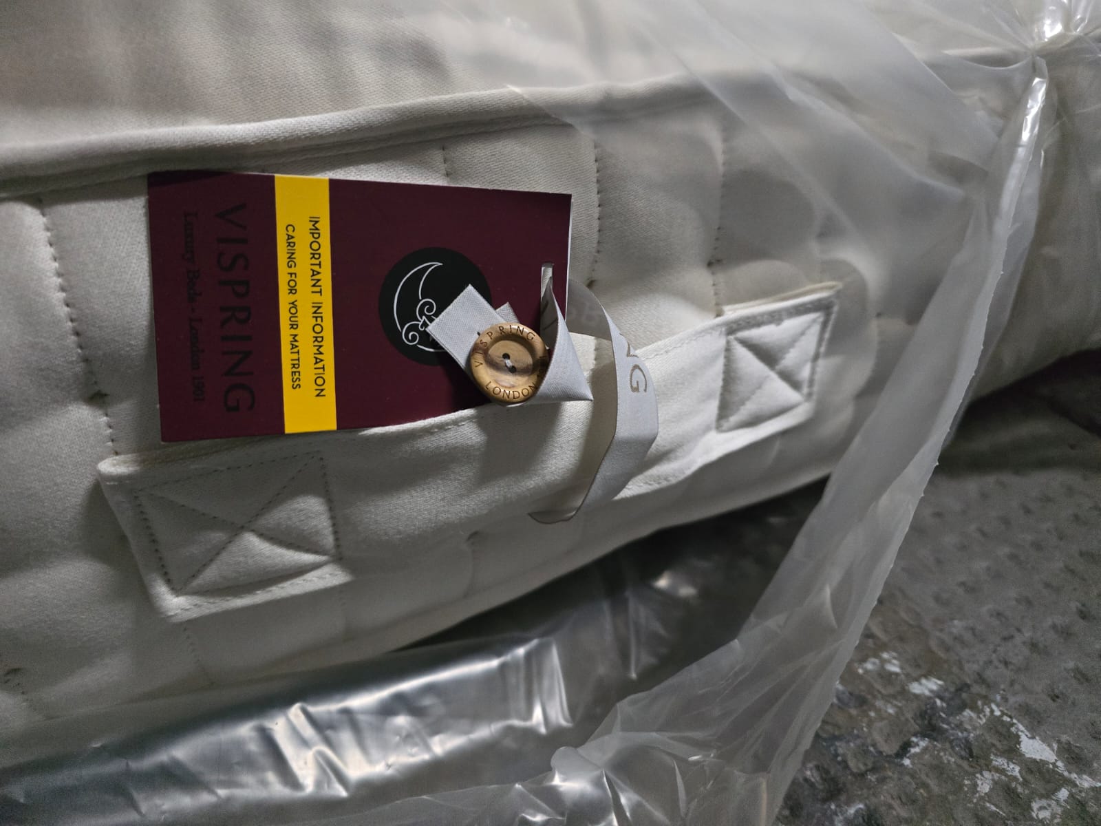 Close-up of luxury emperor size mattress with stitched handles and product tag