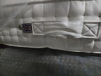 Close-up of luxury white mattress with quilted pattern, fabric handle, and UK flag label