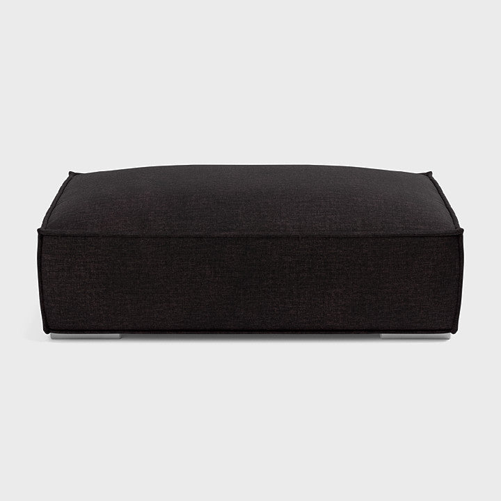 Modern dark fabric rectangular footstool on a plain background, perfect for living rooms.