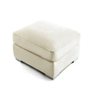 cream upholstered footstool with square cushion top and low profile base on white background