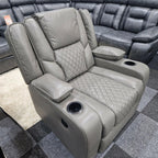 Grey electric recliner armchair with quilted seat, cup holders, and padded armrests