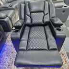 Black leather electric recliner chair with diamond stitching, cup holders, and footrest