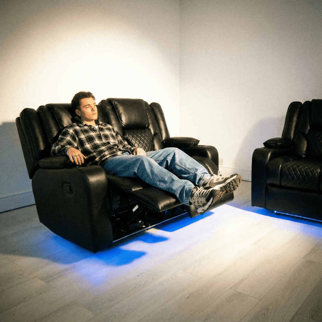 Modern black leather electric recliner sofa set with blue LED lighting and a person relaxing