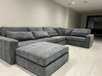 Grey 5-piece modular corner sofa with chaise in a modern living room with light flooring