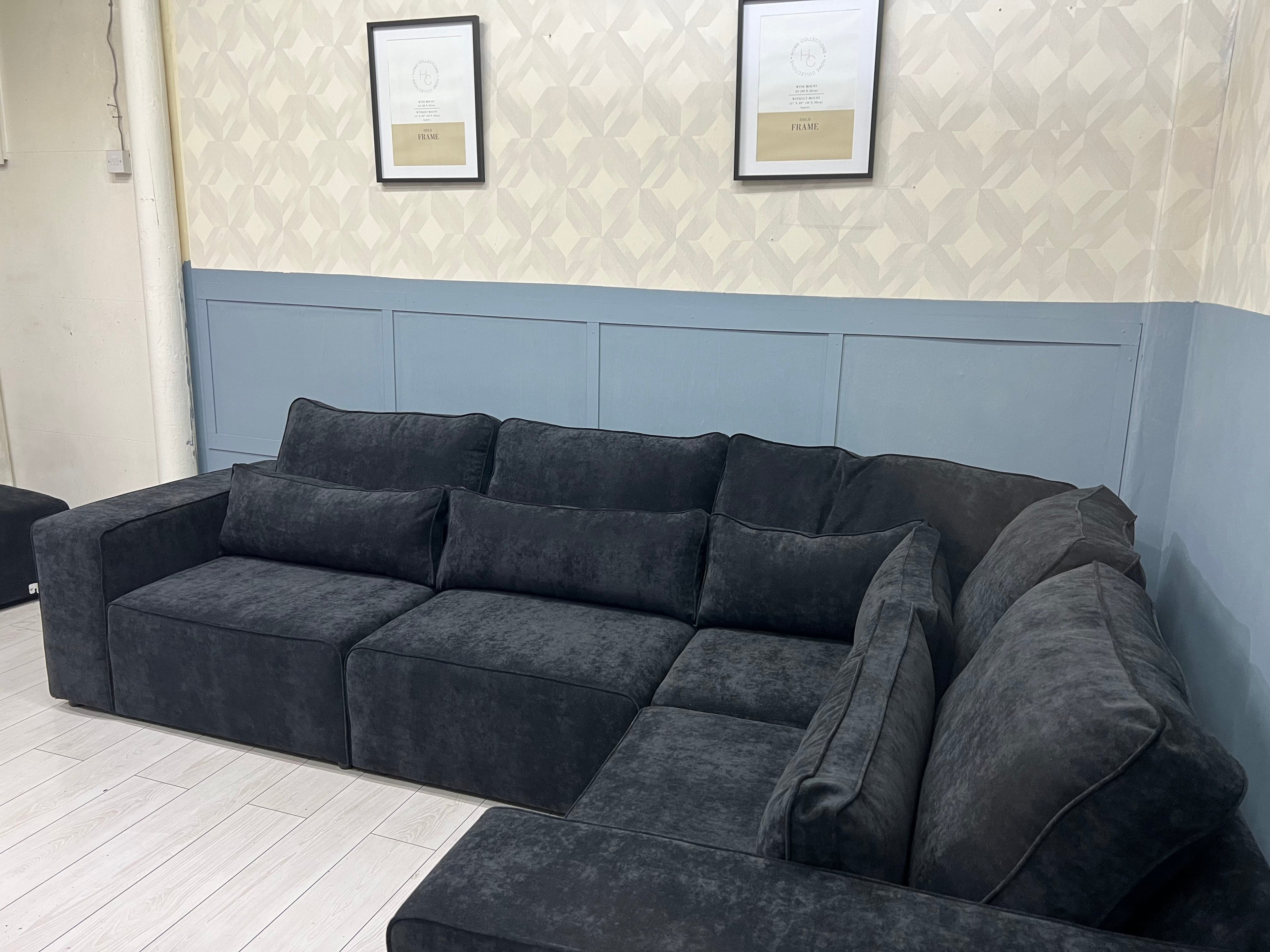 Black modular corner sofa with plush cushions in a modern living room setting