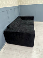 Black modular sofa with plush upholstery in a modern room with light wood flooring